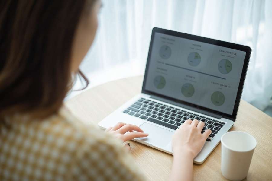 Une graphiste conçoit des graphiques circulaires et des diagrammes de données sur l'écran de son ordinateur portable.